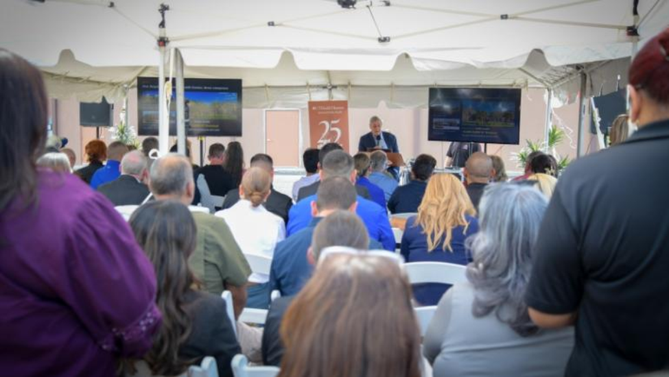 Dr. Joe McCormick speaking at the podium in front of a large crowd